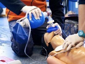 Un adulte donnant des premiers soins de ventilation sur un mannequin