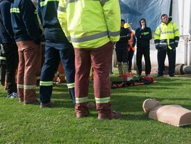 Des adultes en formation de premier secours avec au centre un mannequin