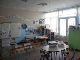 Classe avec tapis de jeux, banc, tables et chaises