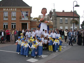 Mirmelène avec l'équipe de porteurs et les enfants tous habillés en bleu et jaune.