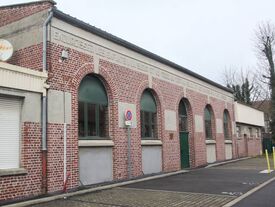 Salle Montaigne en brique, ciment. On peut lire sur le haut du bâtiment , une citation de Montaigne : Endurcissez les enfants à la sueur et au froid, au vent, au soleil et aux hasards qu'il faut mépriser